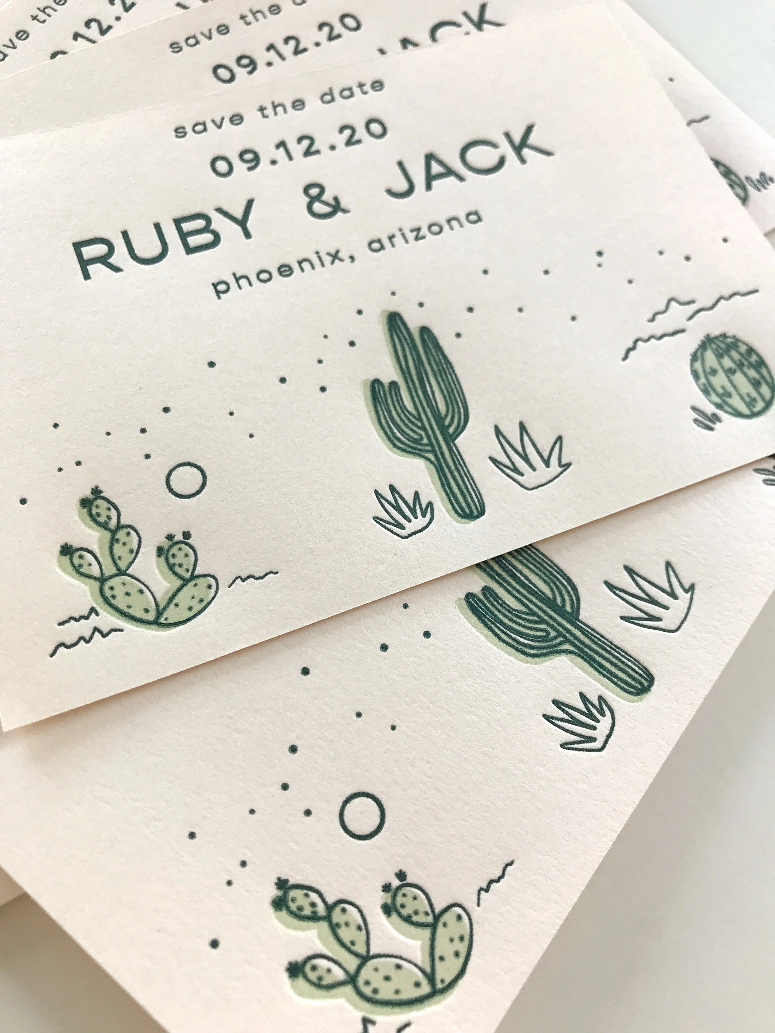 stack of letterpress save the dates with cacti illustrations