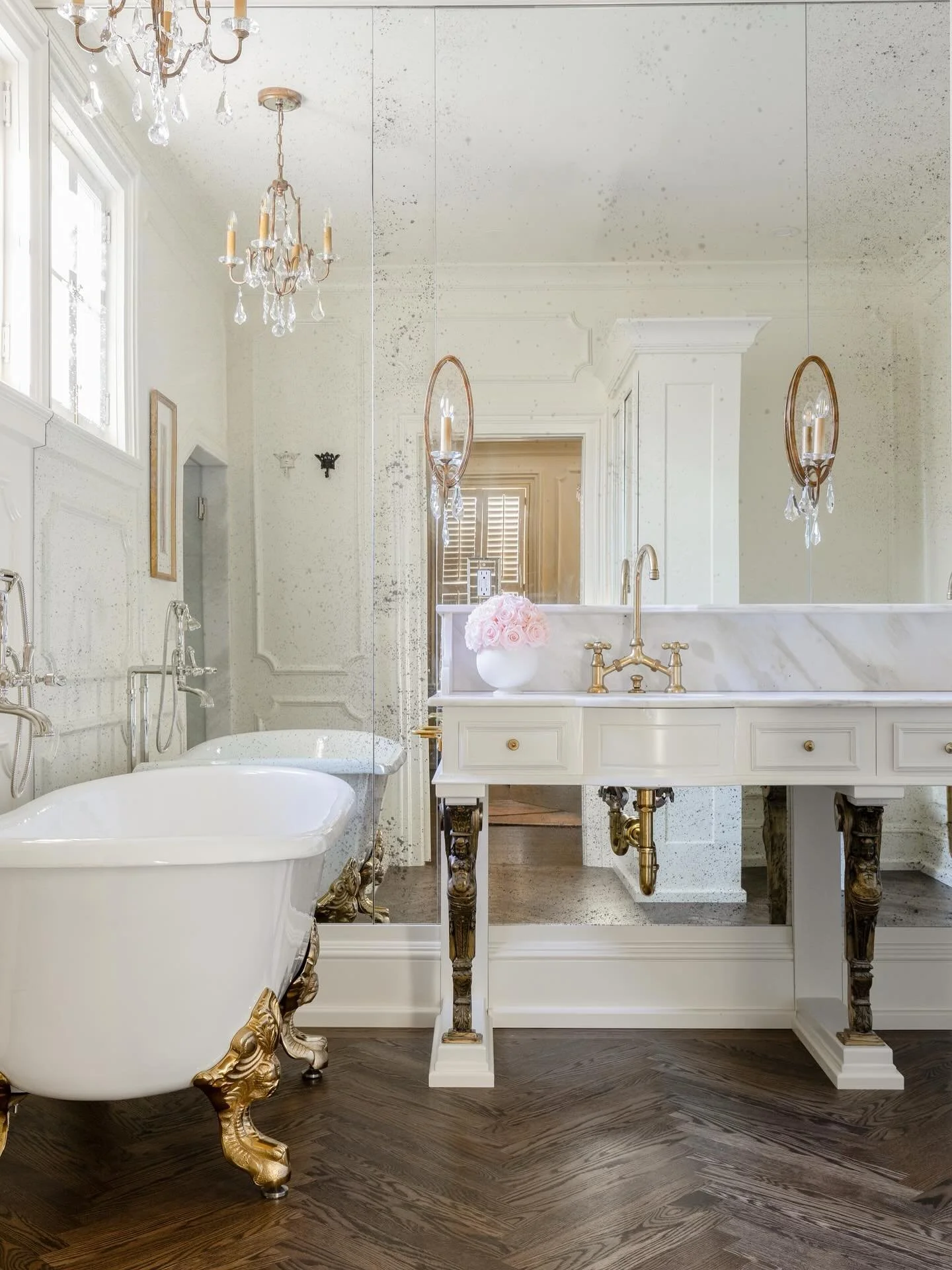 Another space fit for a queen. 👑

This bathroom was a full gut to maximize every inch&mdash;now featuring a marble-wrapped shower, clawfoot tub, and a custom cabinet that adds both division and hidden laundry storage. A French antique mirror wall am