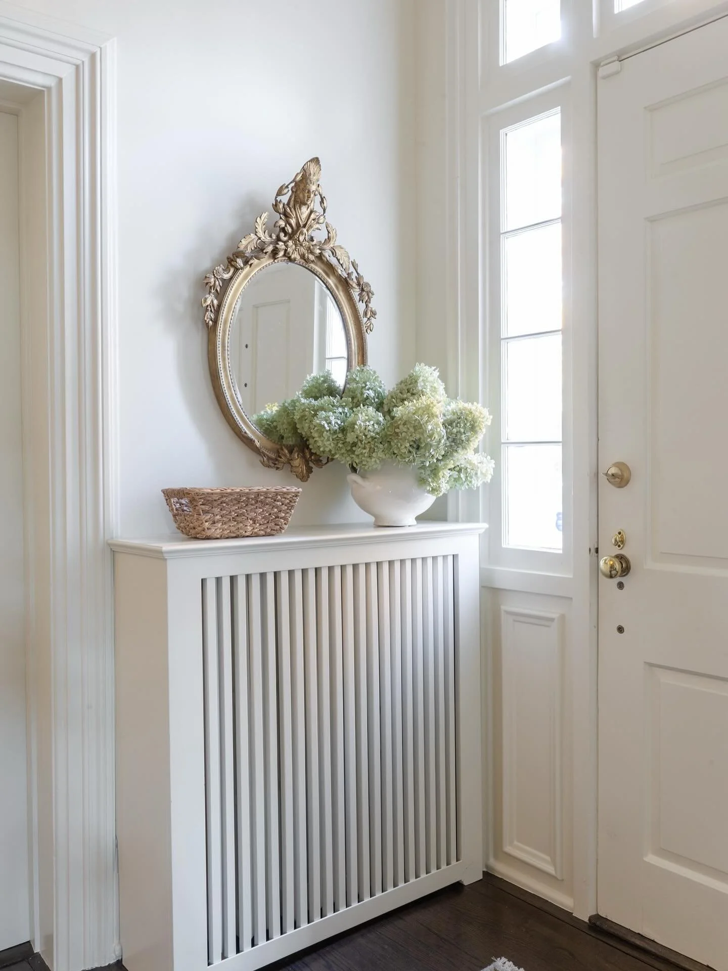 This foyer celebrates the home&rsquo;s original charm while feeling fresh and refined. The original lights and railing were preserved and paired with new paint, a soft stair runner, and custom stair rods that bring subtle sophistication to every step