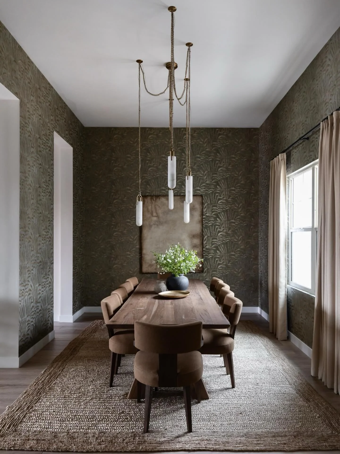 Statement lighting sets the tone, wallpaper adds depth, and natural wood brings warmth. Thoughtful layering turned this dining room into a true focal point within the home.