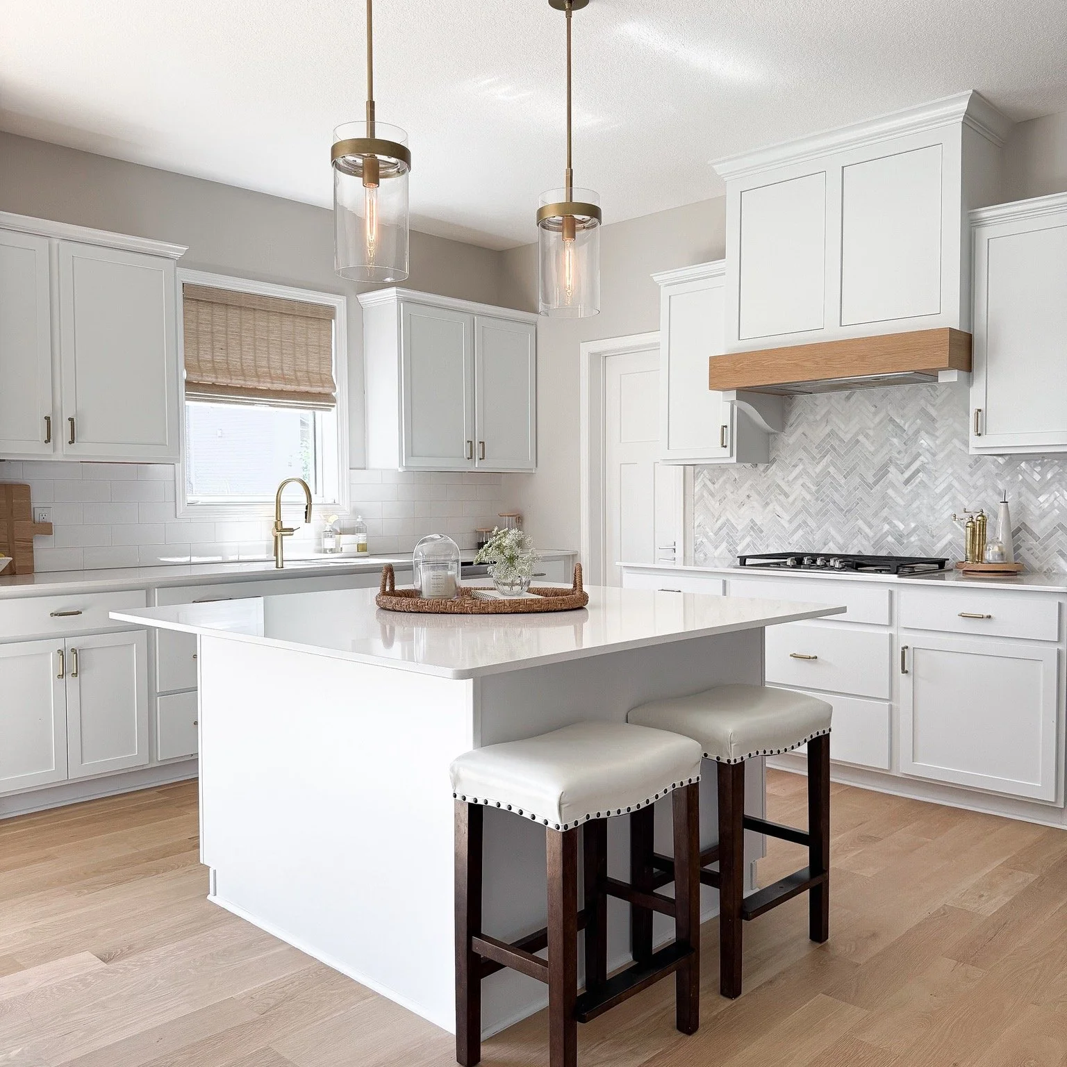 You don&rsquo;t always need to start from scratch to make a builder-grade kitchen feel more custom.

A new hood was designed around the existing uppers, along with a new backsplash, lighting, hardware and faucet. Roll-out shelves were also added to t