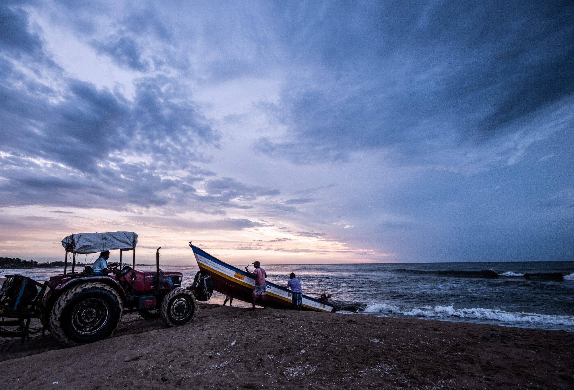  A tractor is utilized to push the boats into the surf in the morning 
