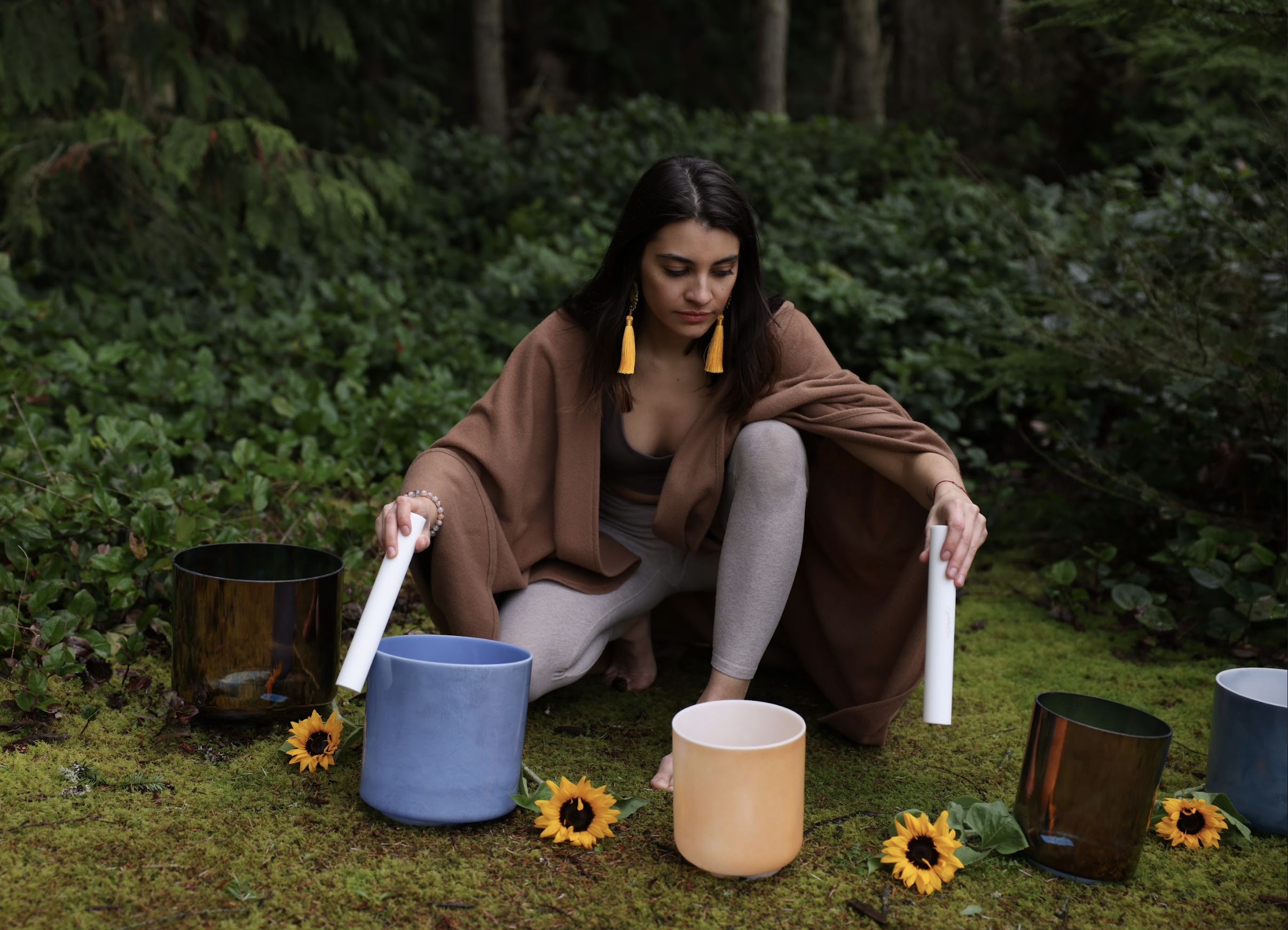 Portrait of Fiona Baqai owner of Soundflower.co playing sound bowls in forest