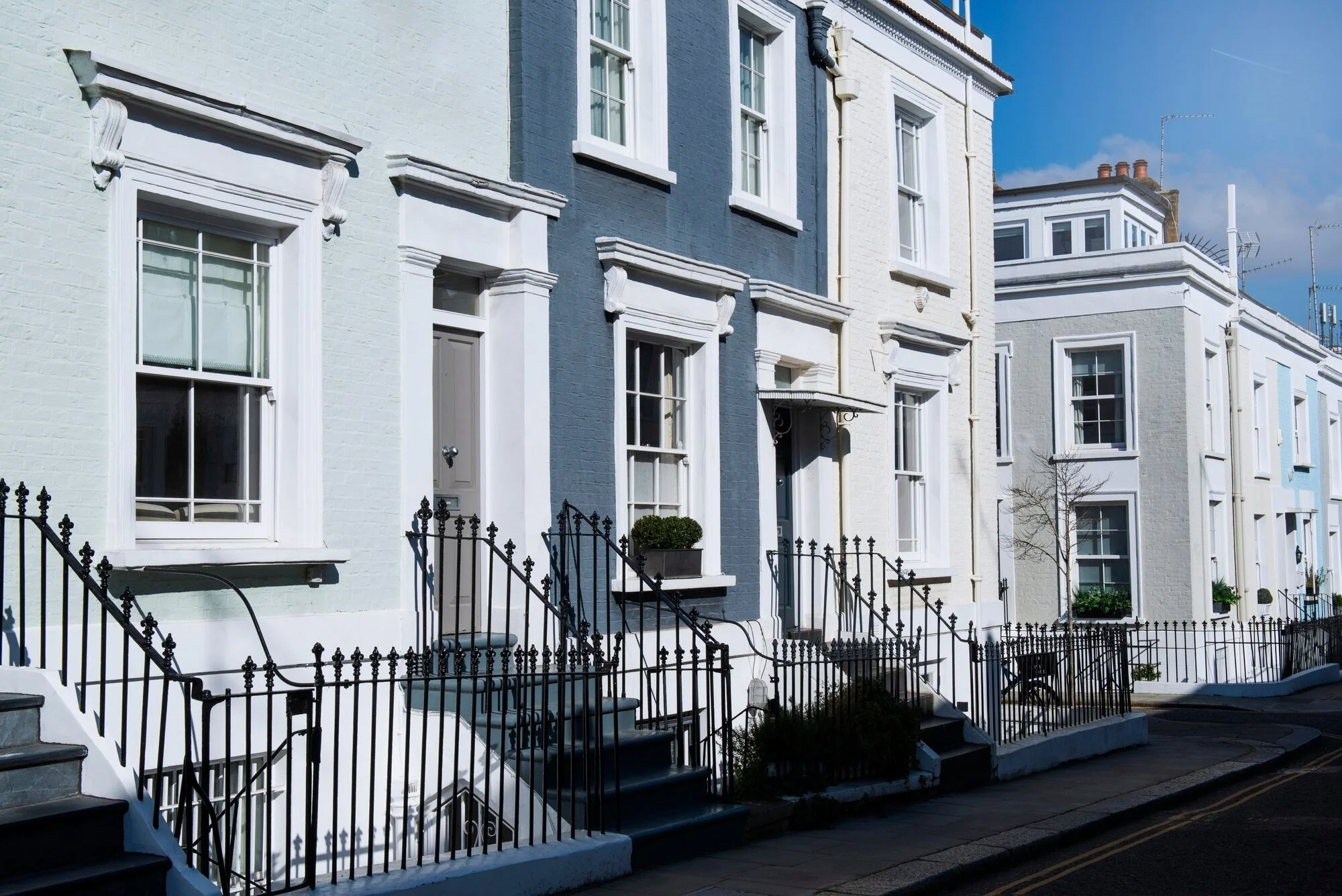 A row of houses painted in white and blue, showcasing a charming neighborhood aesthetic
