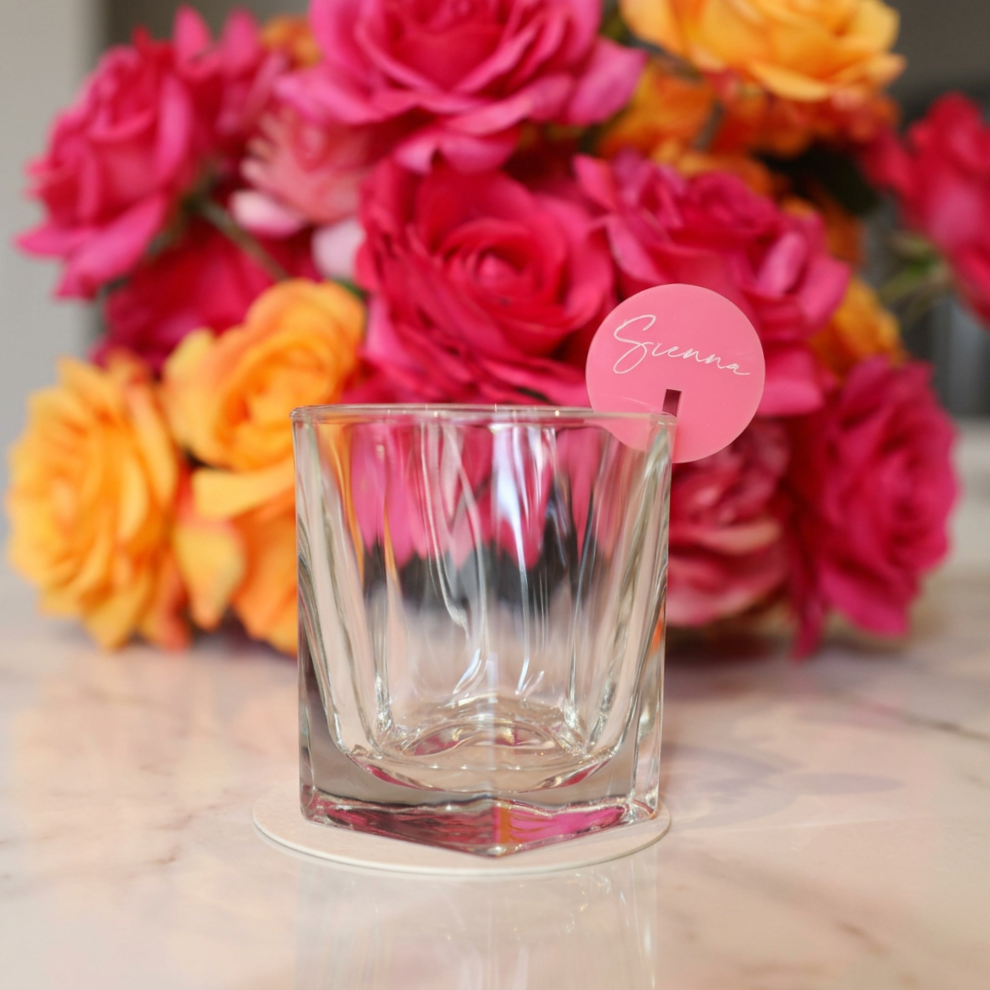 Round acrylic drink markers fitted onto glass rims for wedding and party styling