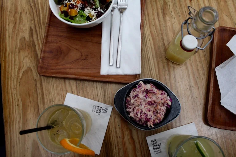 Three Buns is more than just a hamburger joint, they also serve a good range of salads and juices. Clockwise: Beets By Dre salad, Ginger Ninja juice, House Side, LL kool slaw.