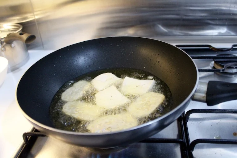 Soak the tempe and tofu in a bath of water, chopped garlic and salt, dry then shallow fry in vegetable oil until golden brown