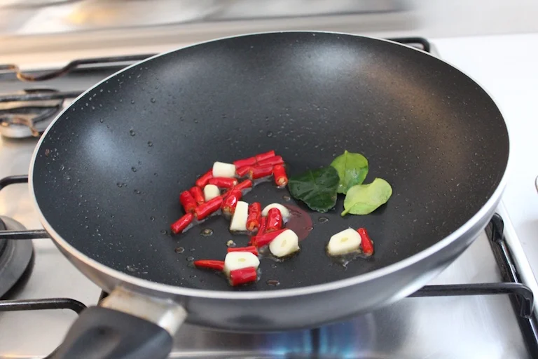 Stir fry the chilli, garlic and kaffir leaves for 2 - 3 minutes to release the flavours