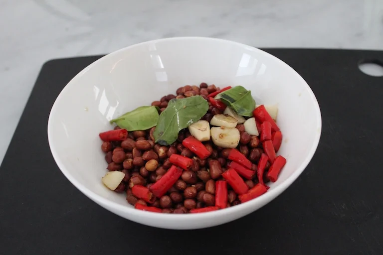 Add the cooked peanuts to the chilli, garlic and kaffir lime