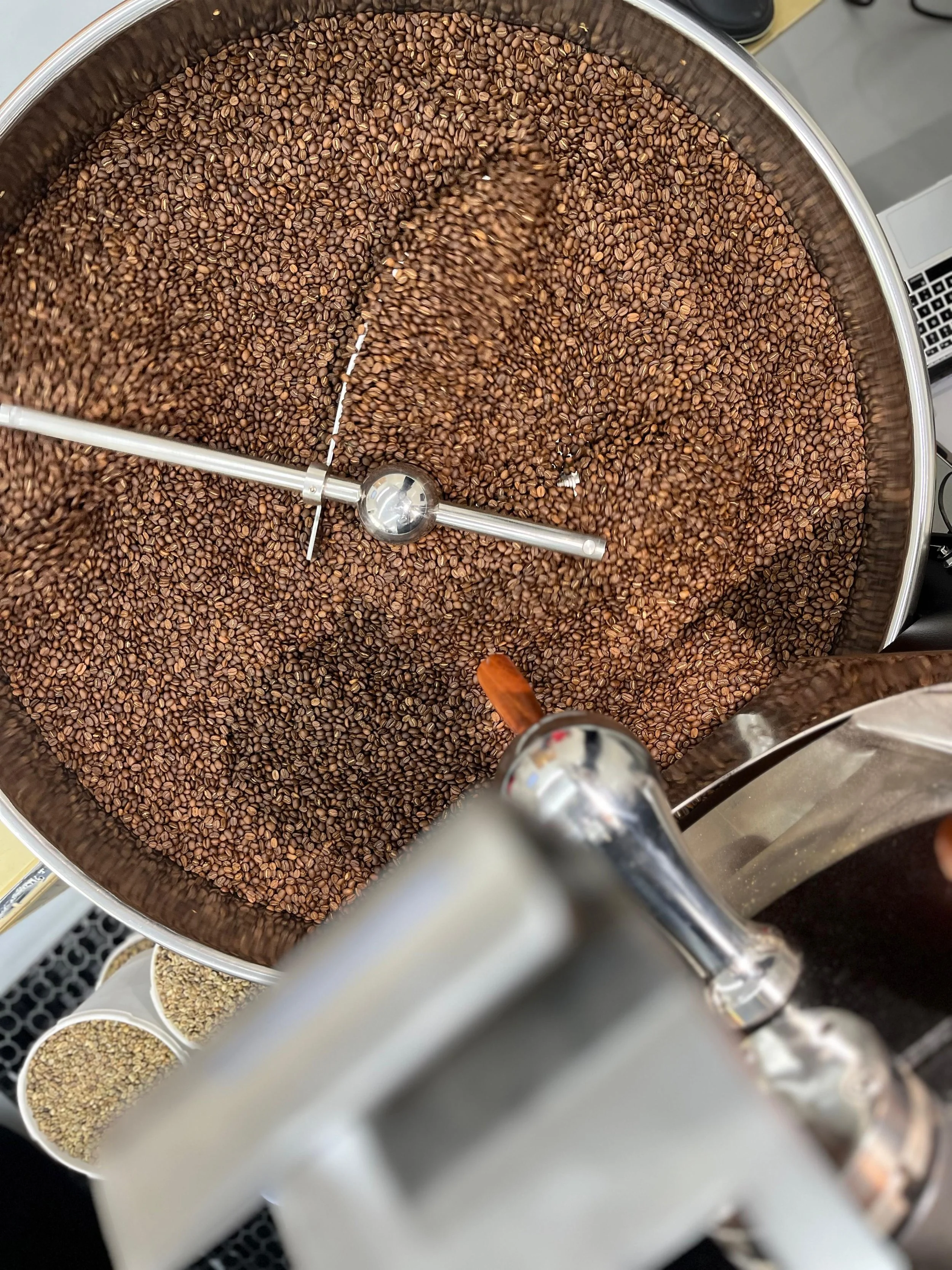 Close-up of a large, industrial coffee roasting machine filled with roasted coffee beans.