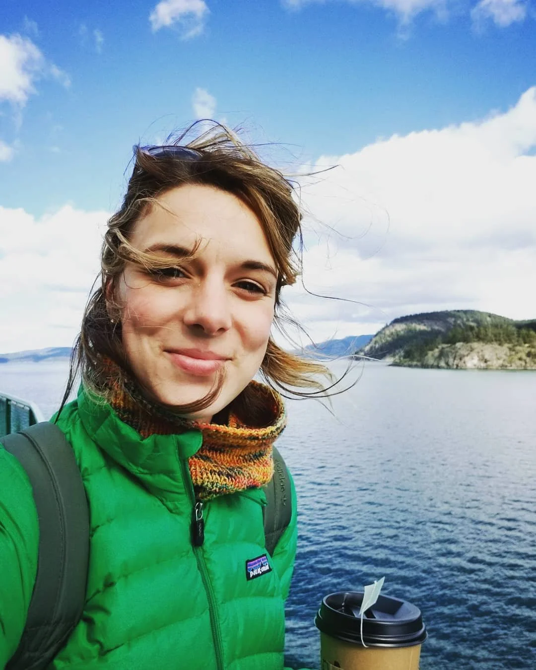 Selfie of Nicole in front of a blue body of water