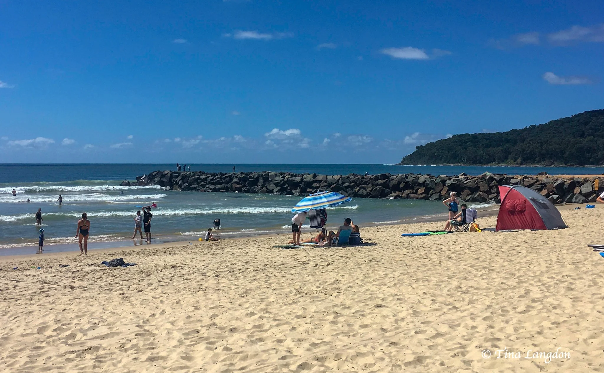 People enjoying sunbathing and swimming at Noosa beach, Queensland, Australia