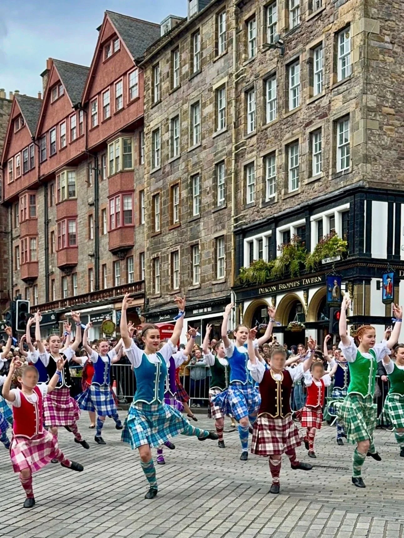 Female Scottish dance group dressed in colourful tartan outfits dancing at the Edinburgh Tartan Parade