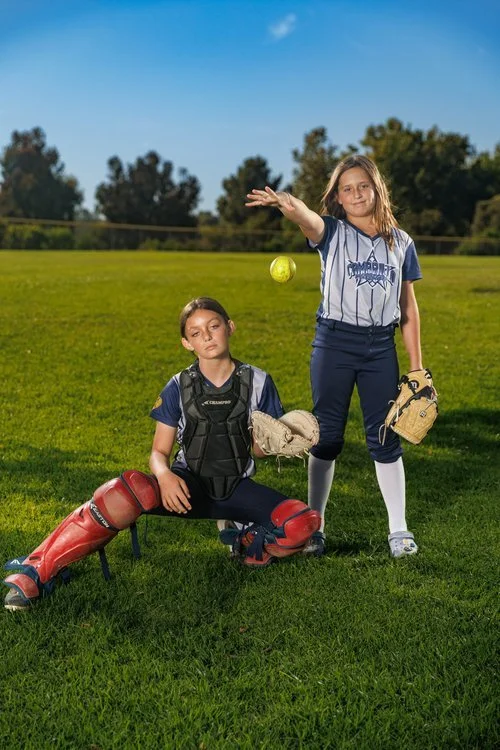 two girls play catch with softball