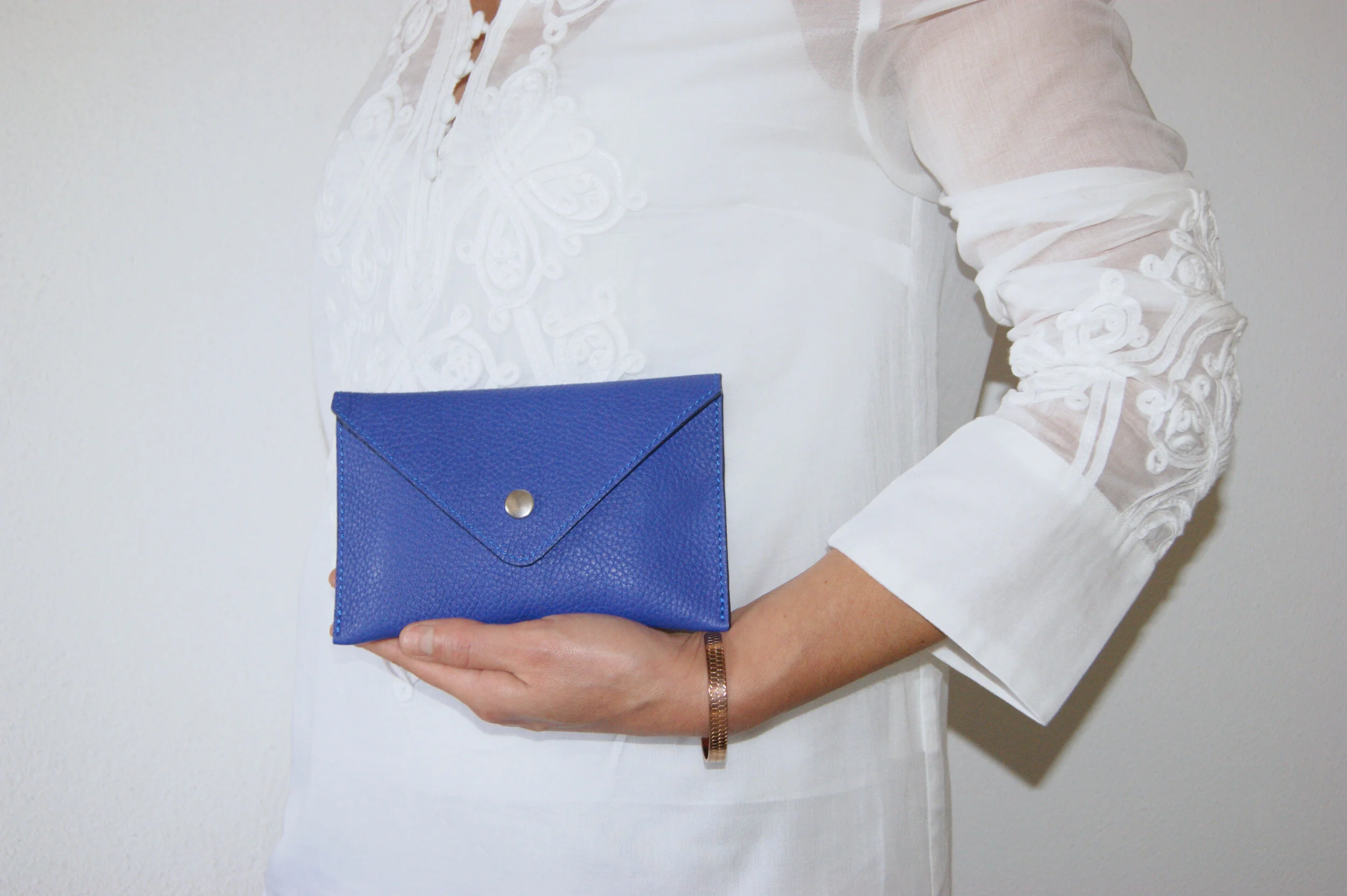 petite pochette cuir grainé bleu intérieur métallisé argent portée main