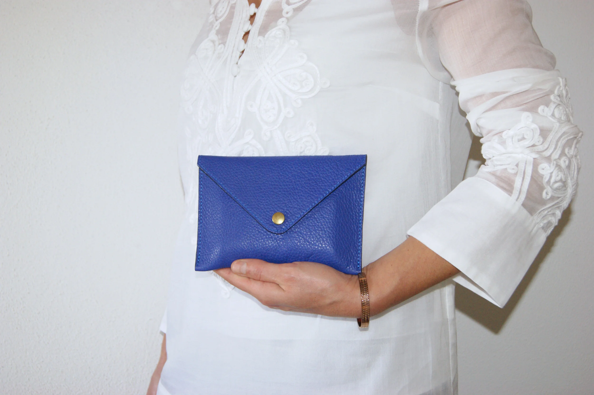 petite pochette cuir grainé bleu intérieur métallisé rose gold portée main