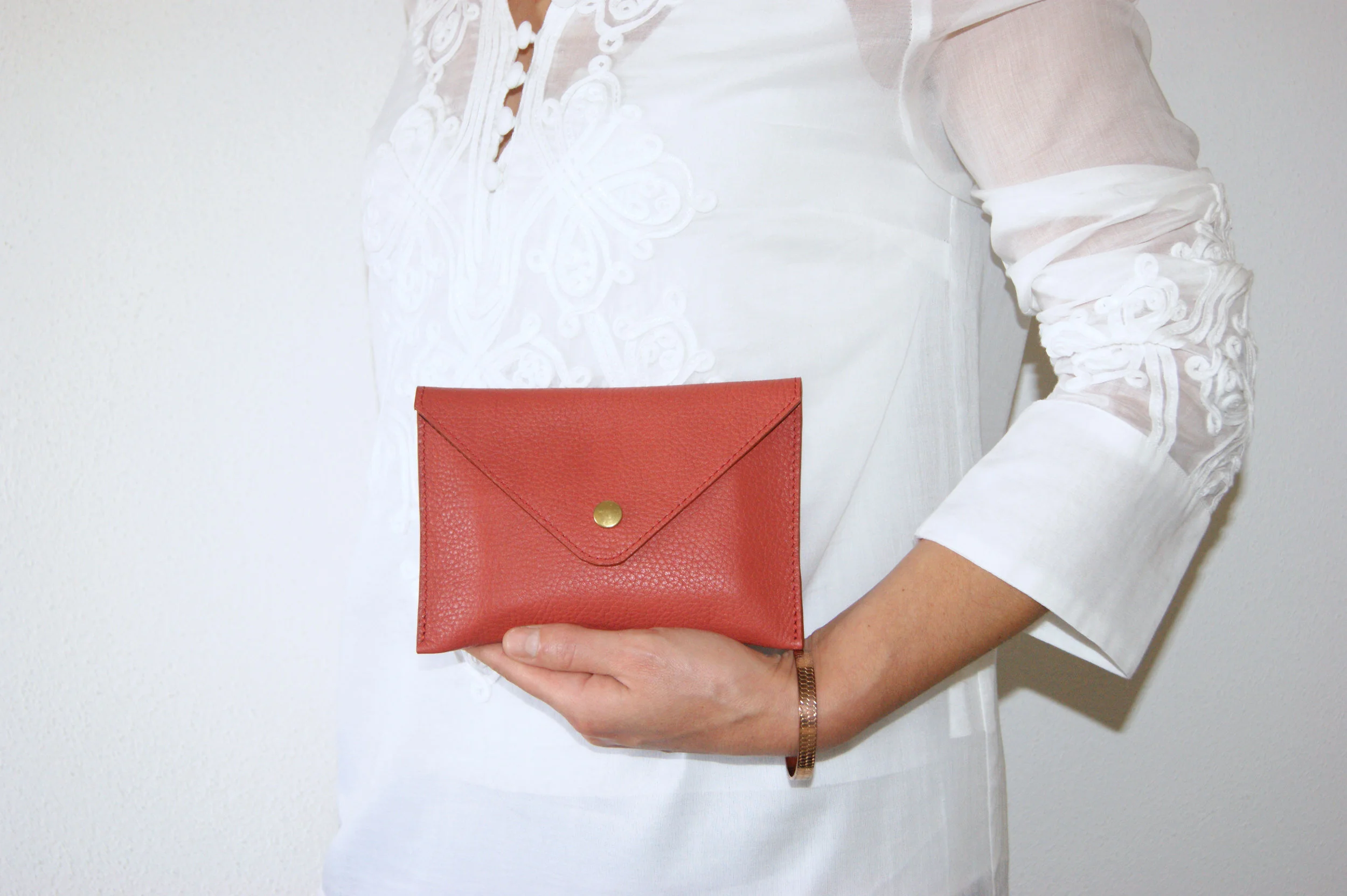 petite pochette cuir grainé rouille intérieur métallisé rose gold portée main