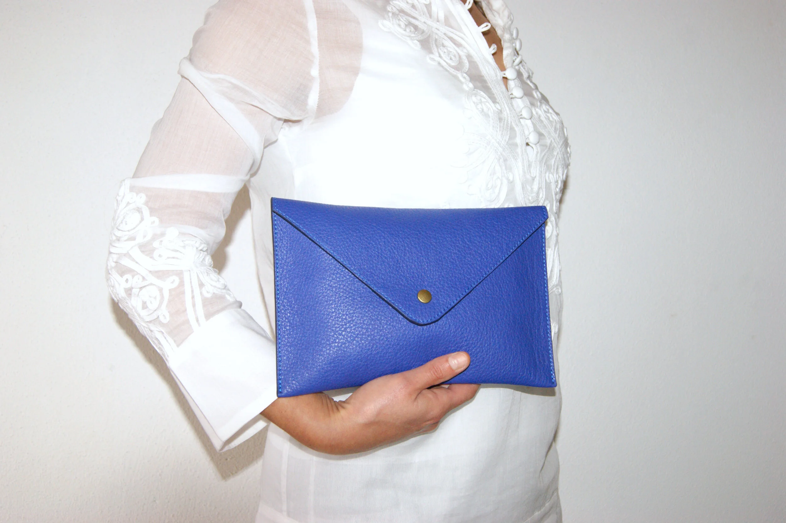 grande pochette cuir grainé bleu intérieur métallisé rose gold portée main