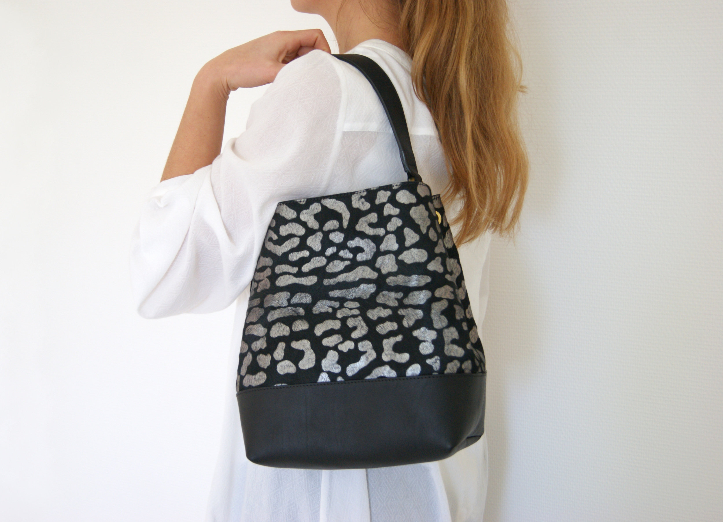 petit sac cuir poils léopard couleur noir taches couleur argentée porté épaule