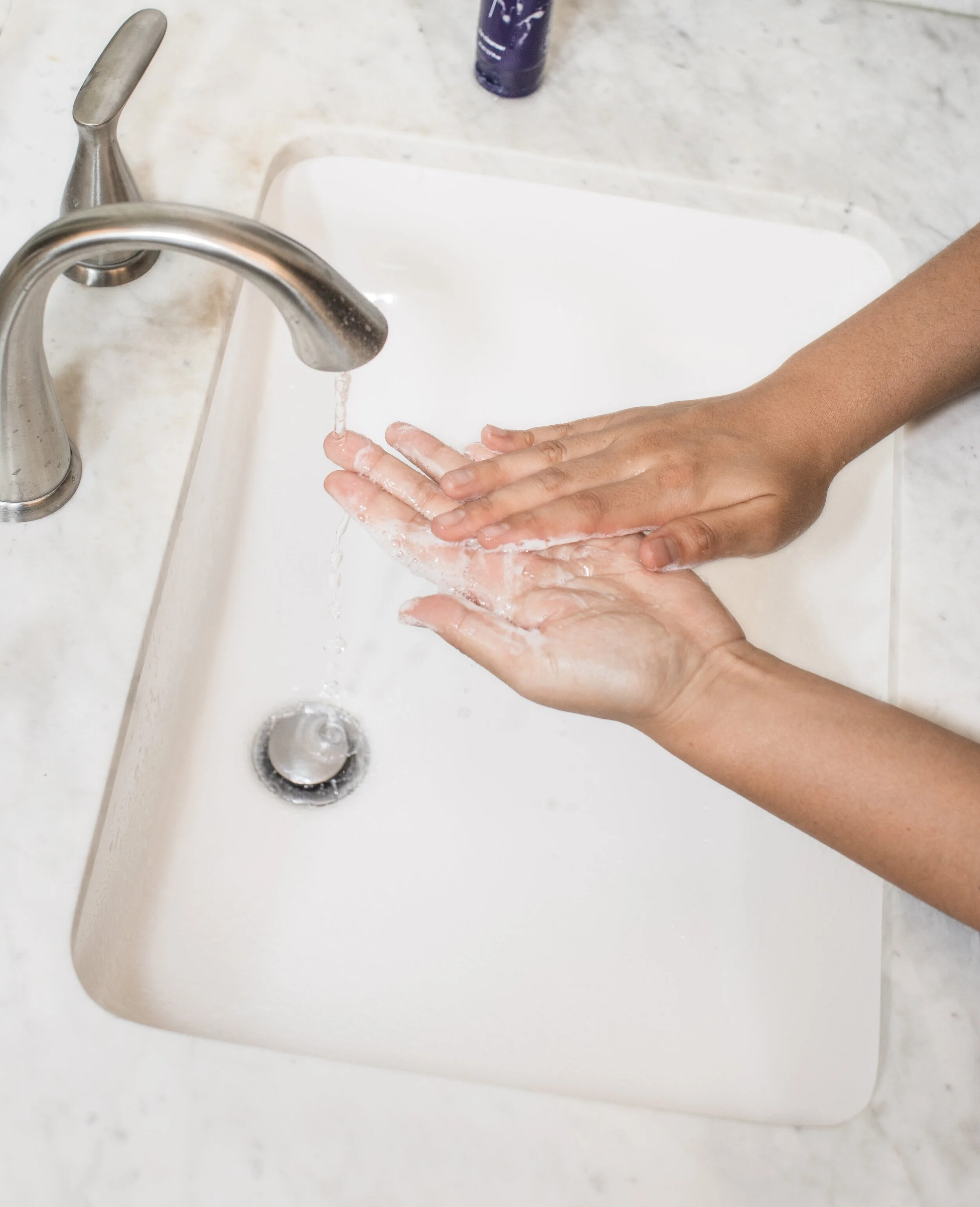 Person washing hands in a sink