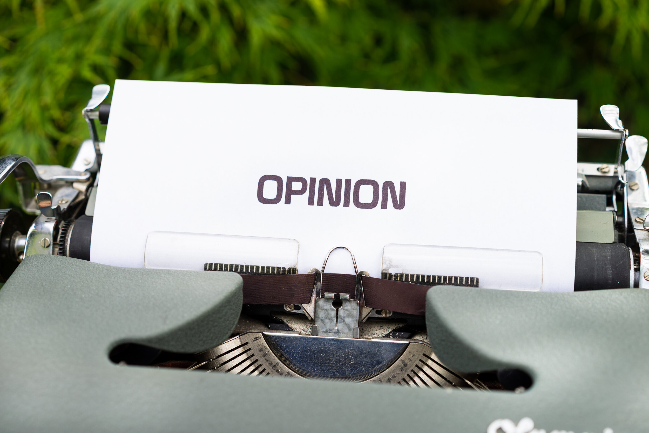 the word Opinion typed paper coming from typewriter