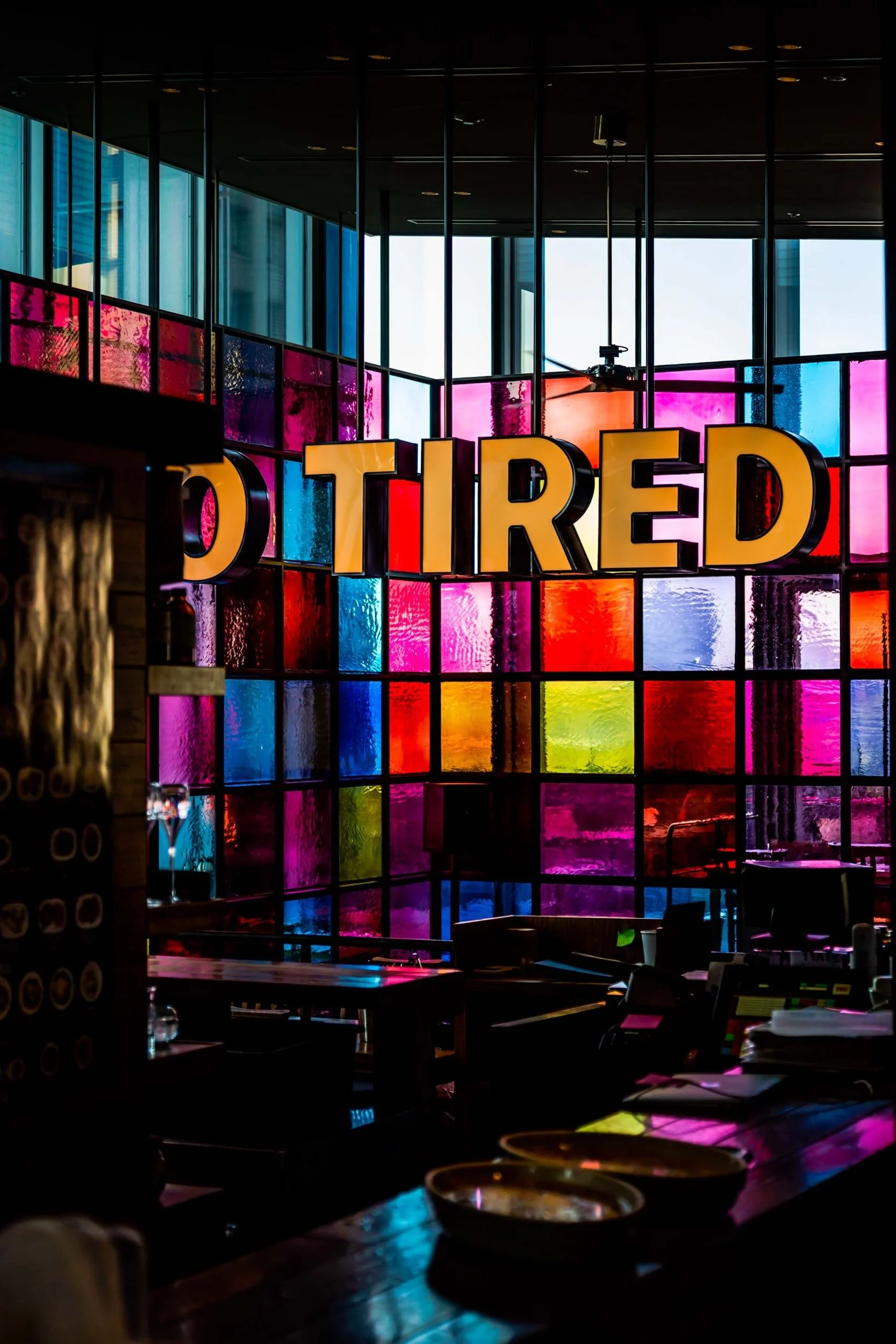 Tired sign in front of multi-colored glass