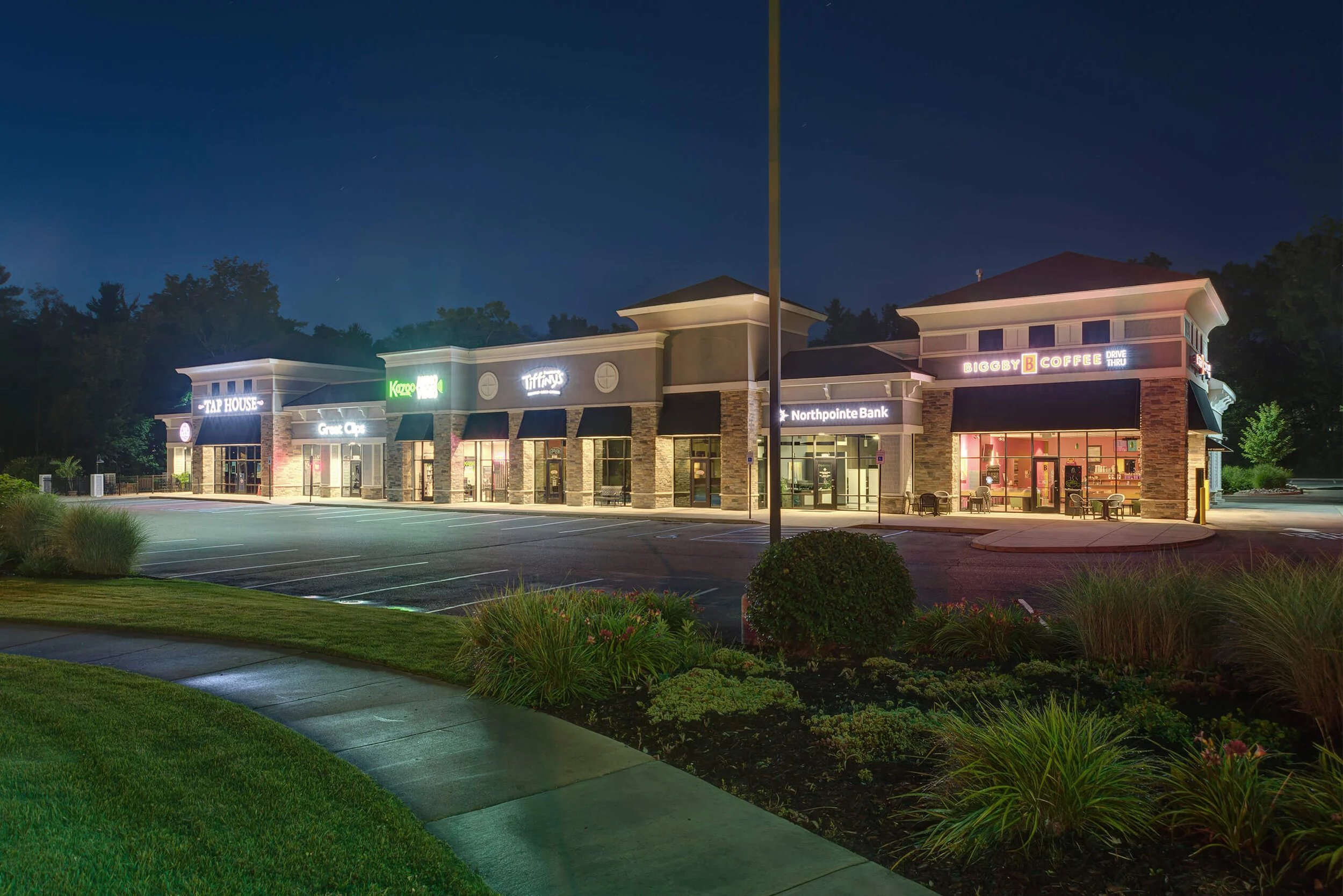 Evening photo of local business including a restaurant, coffee shop and bank. 