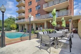 Outdoor pool and patio area includes ample seating and multiple grills.