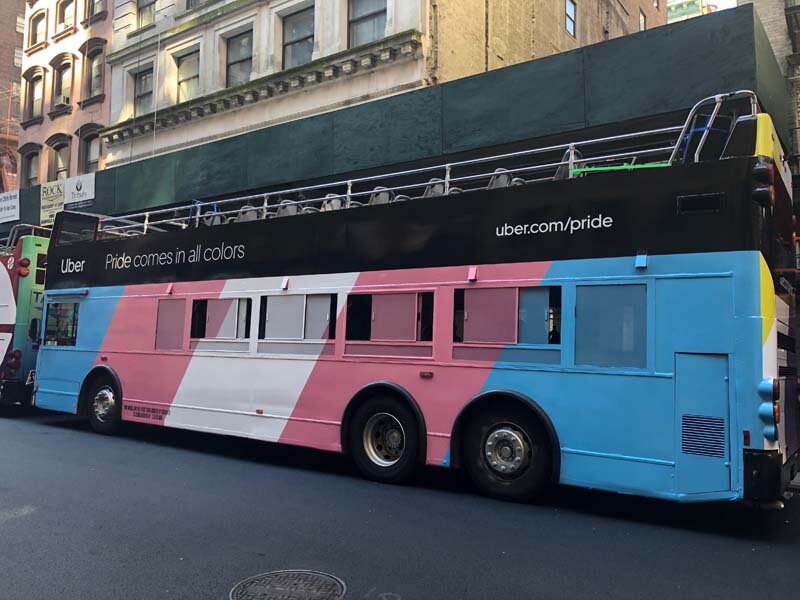 double decker bus side view with transgender flag colors