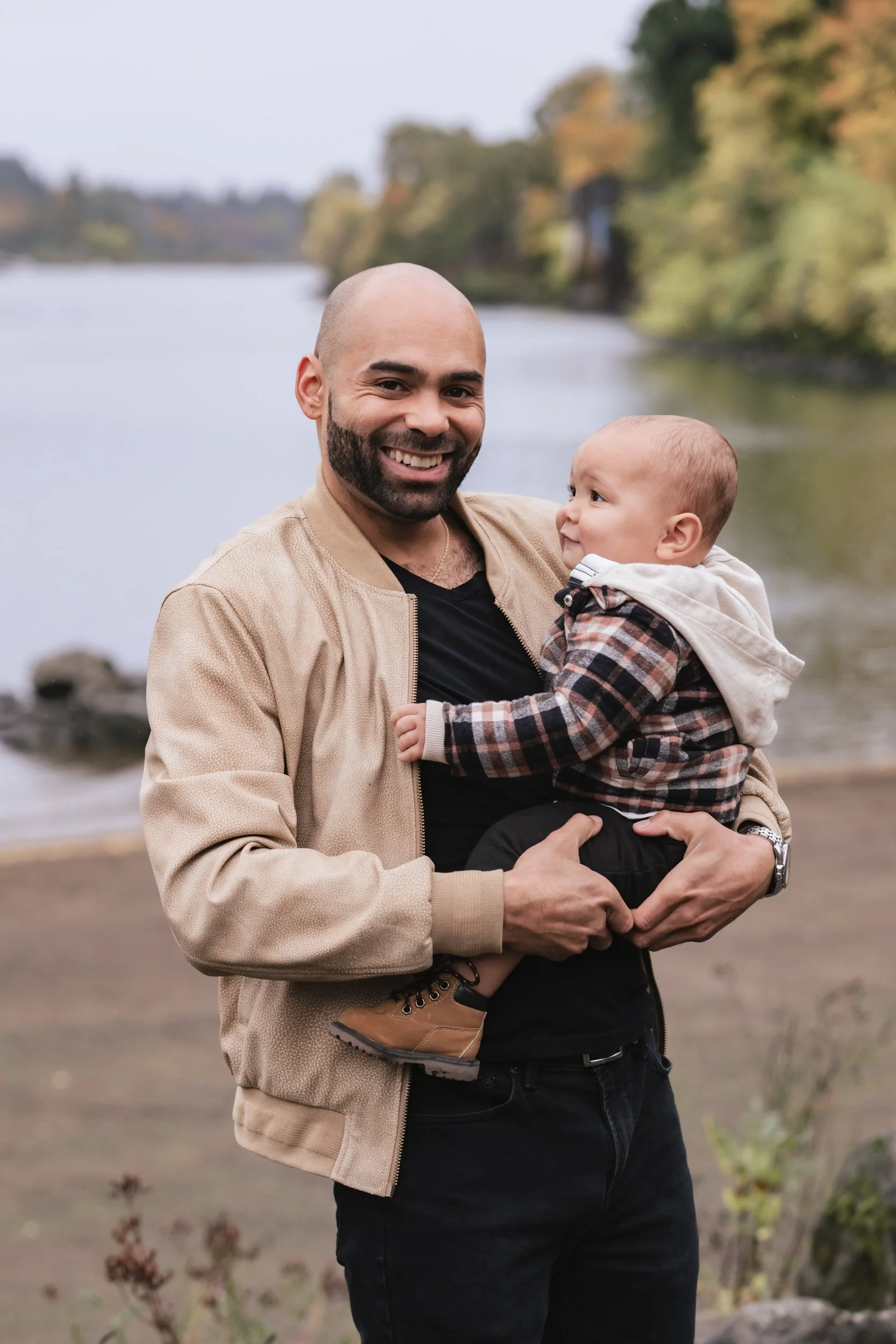 A dad holds his baby during a rainy photoshoot.