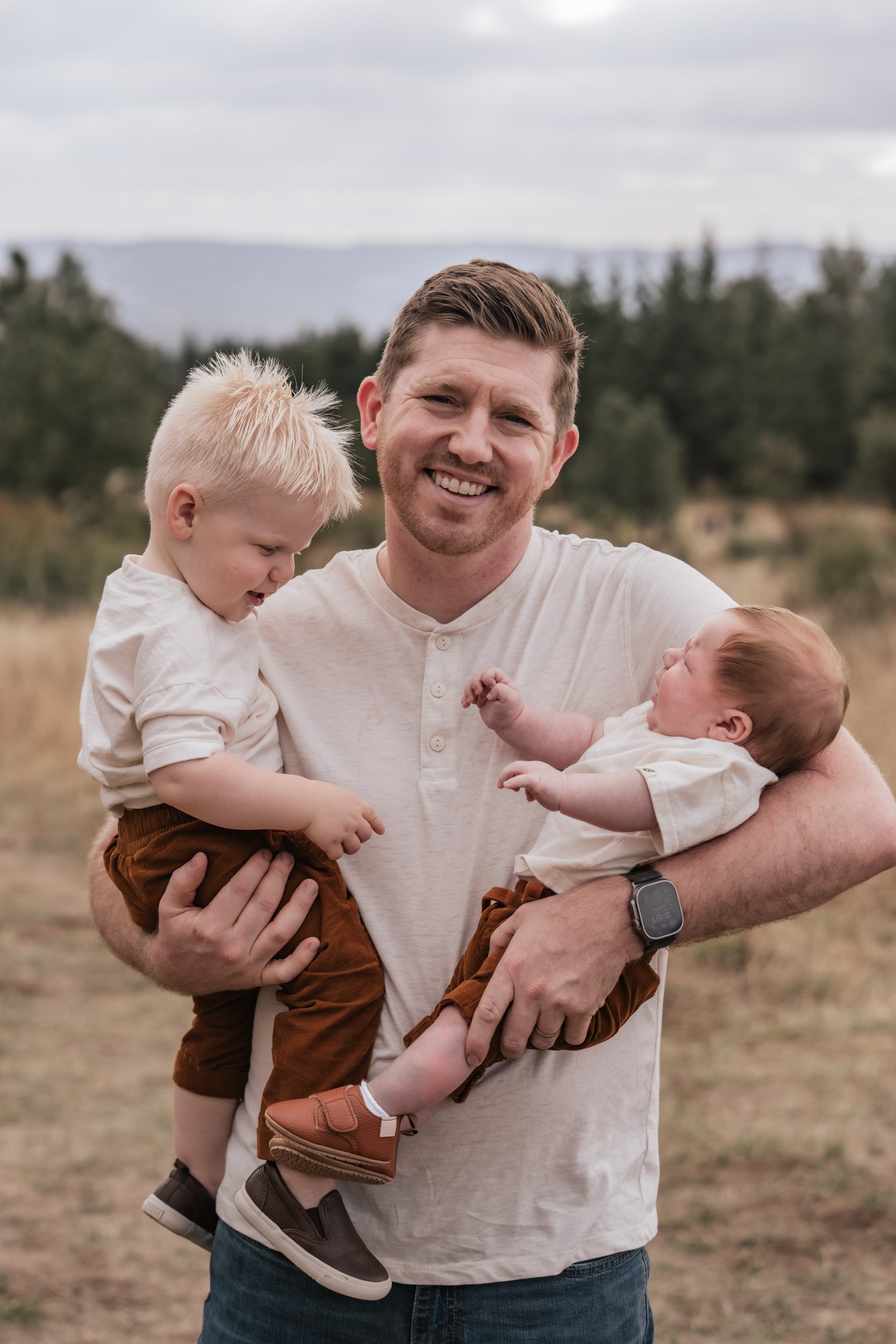 A dad holds his two sons at Cooper Mountain Park.