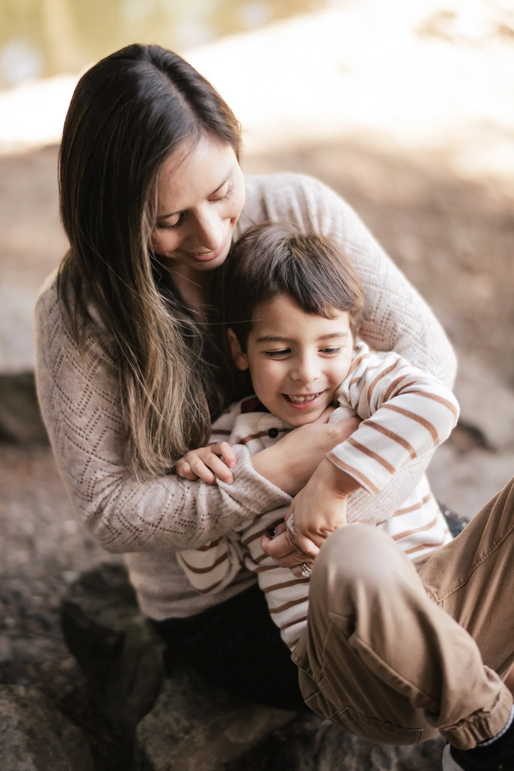A small boy sits in his mom's lap.