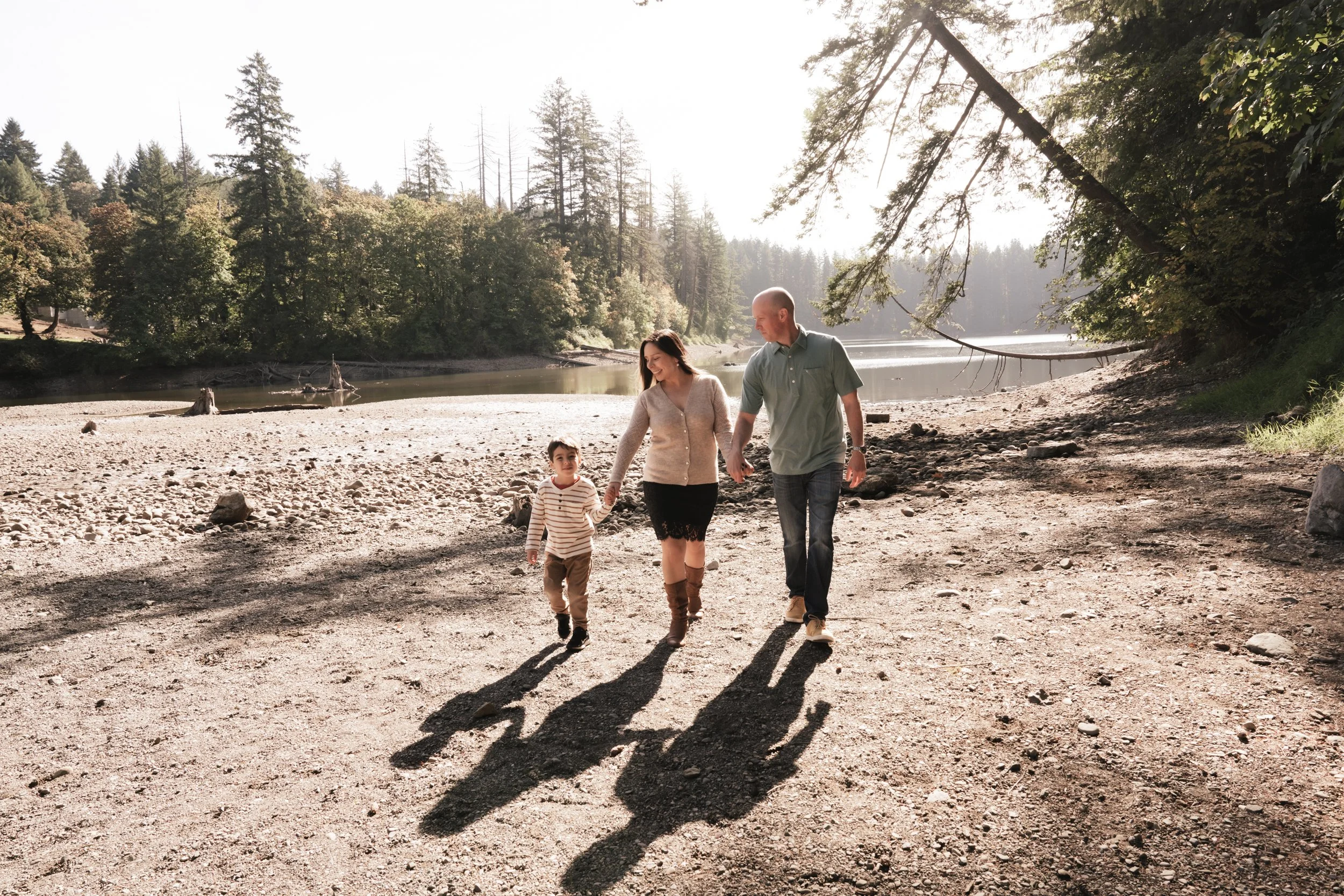 Long shadows stretch from a family of three at Lacamas Lake.