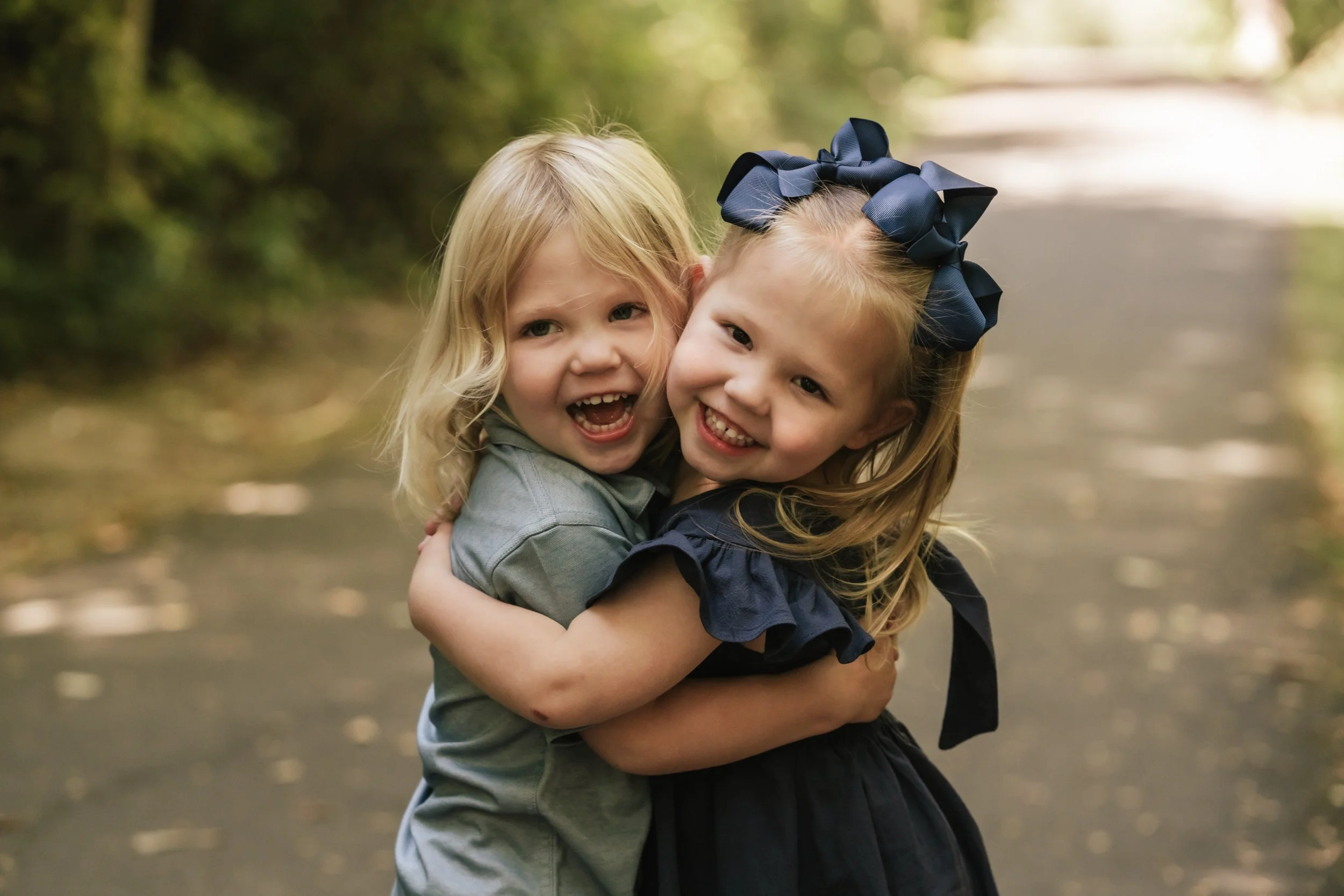 Two twins hug each other tightly.