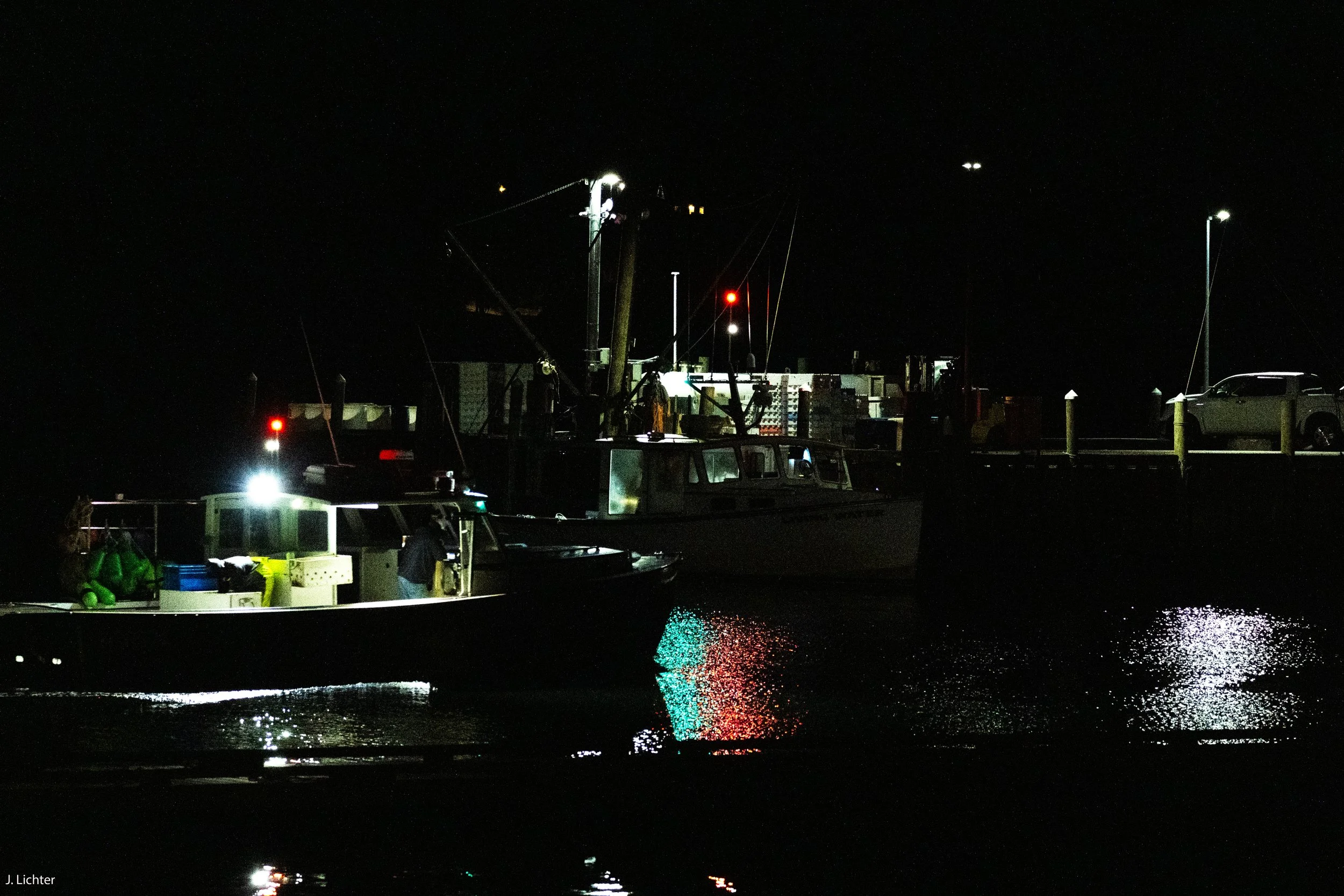 Lobster fishermen loading bait before dawn.  Stonington, Maine.