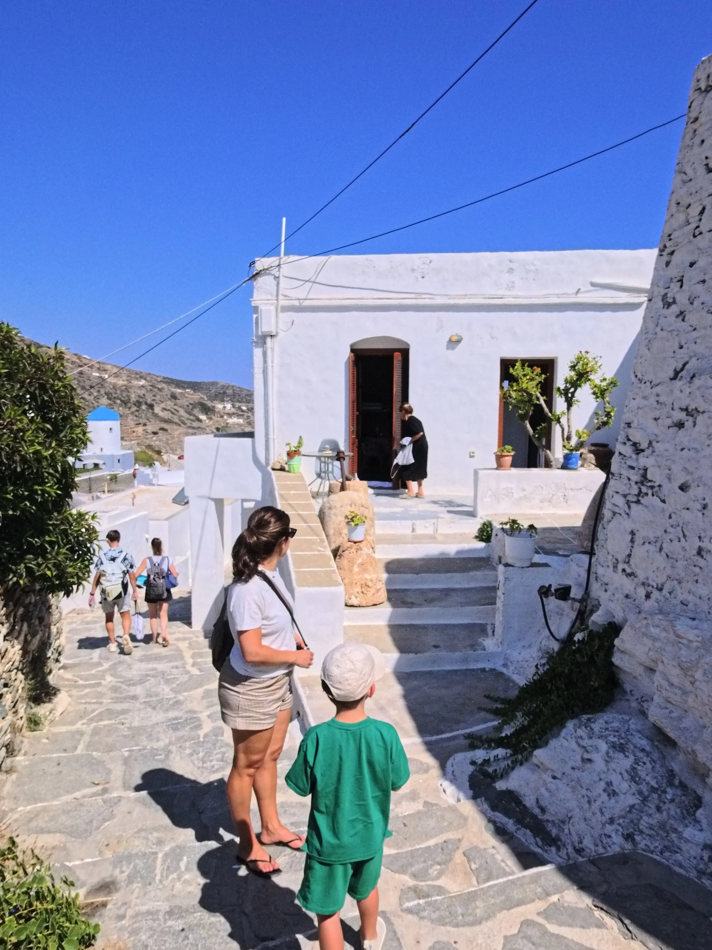 Family observes an older woman in Kastro, Sifnos