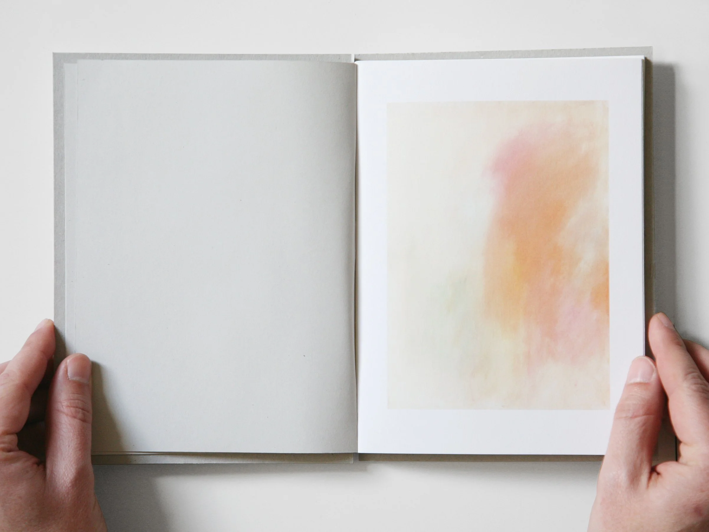 A white notebook featuring a detailed drawing on its cover, placed on a wooden surface.
