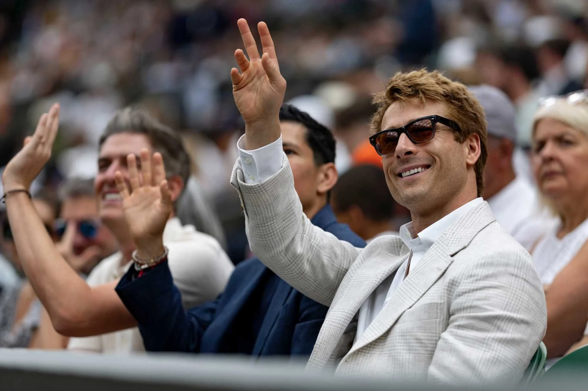 Actor Glenn Powell at Wimbledon in a light plaid jacket and white shirt