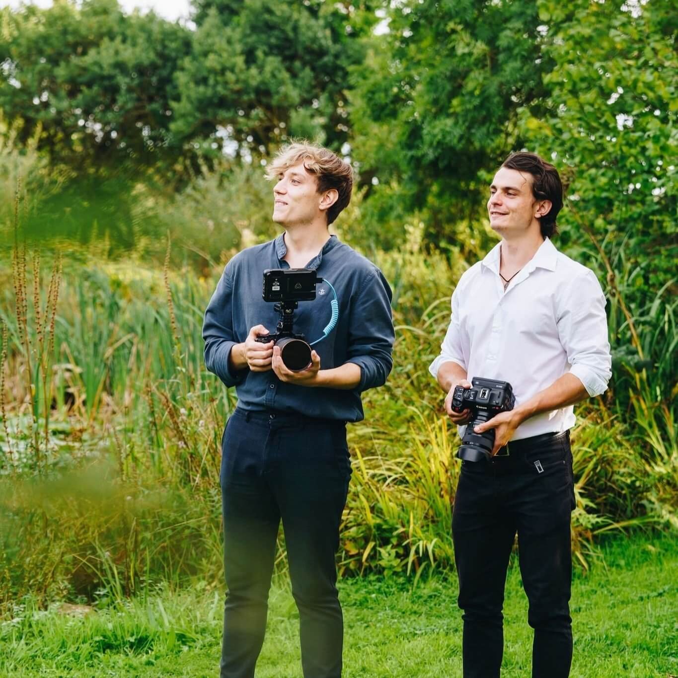  Chris and best friend Luke standing holding video cameras at wedding 