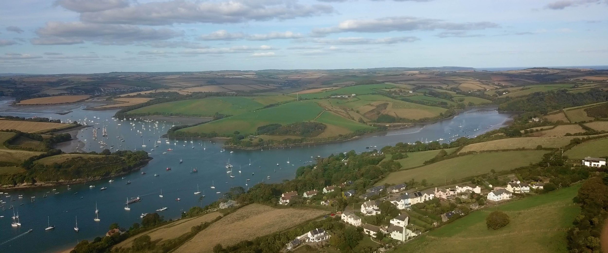 Aerial drone shot of the Salcombe Estuary showing the fields and where two rivers meet.
