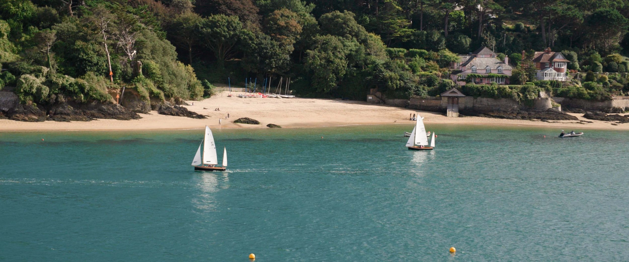 A close up shot of the pretty sail boats saling down the river of Salcombe Estuary