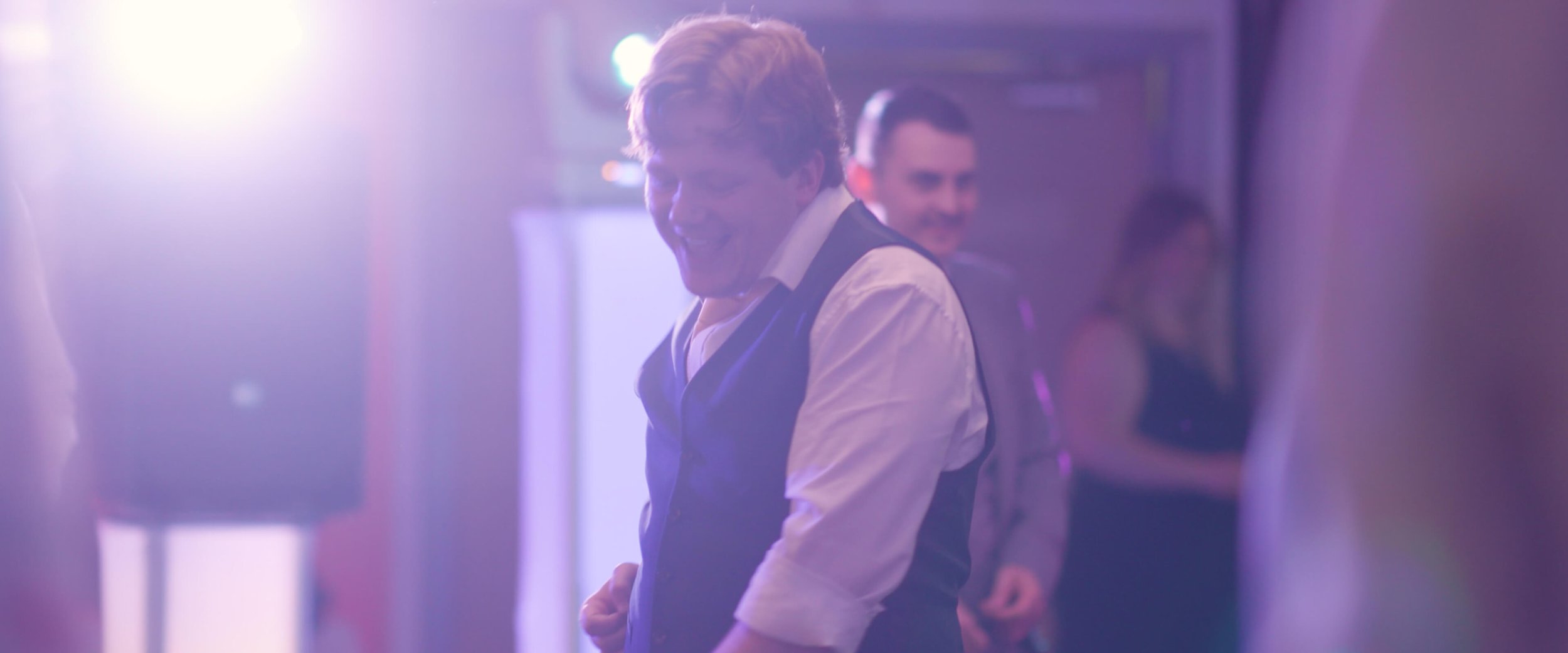 Dael pulling off some impressive dance moves as the wedding DJ's light shines on him.
