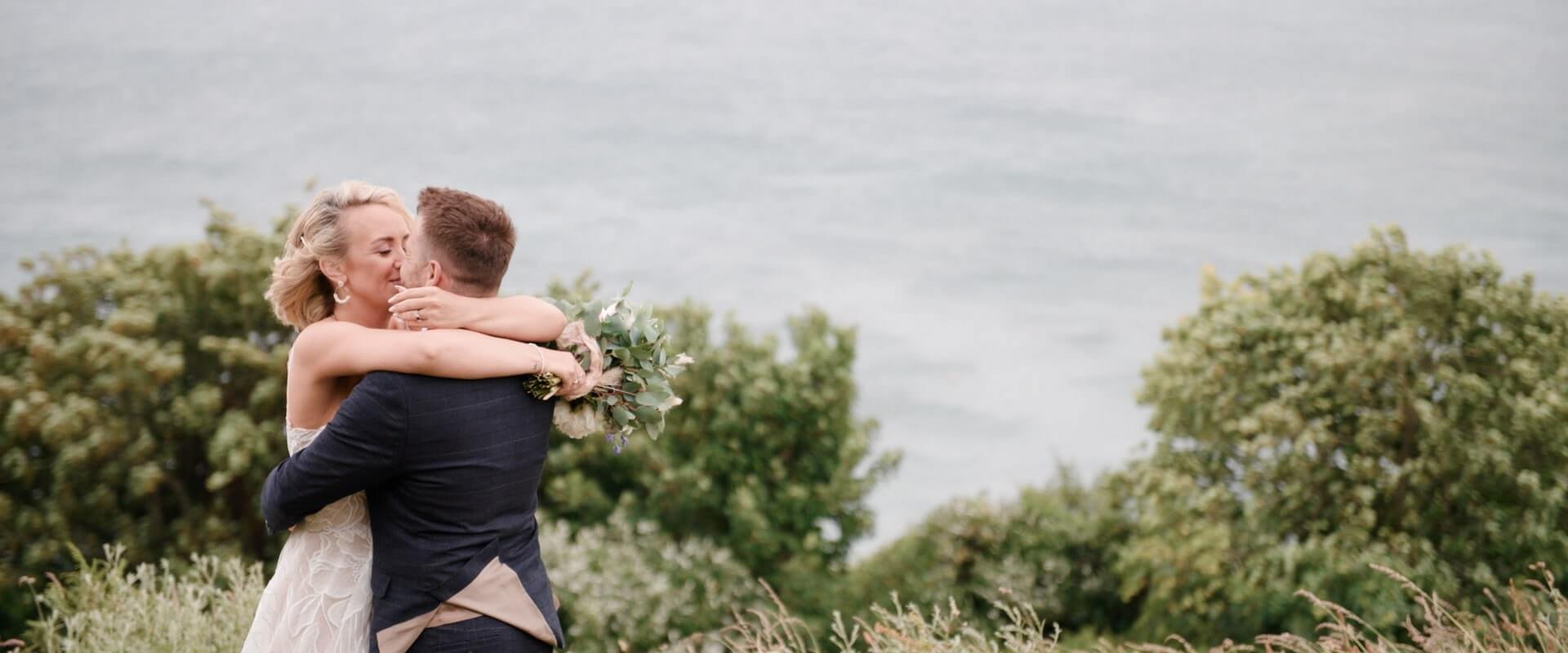 Michelle &amp; Chris embrace at Samphire Beach (Looe) for a photo