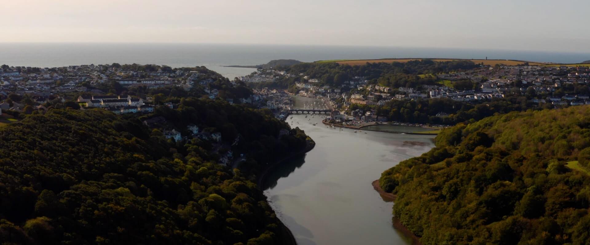 An aerial drone shot of where the East Looe River meets the town