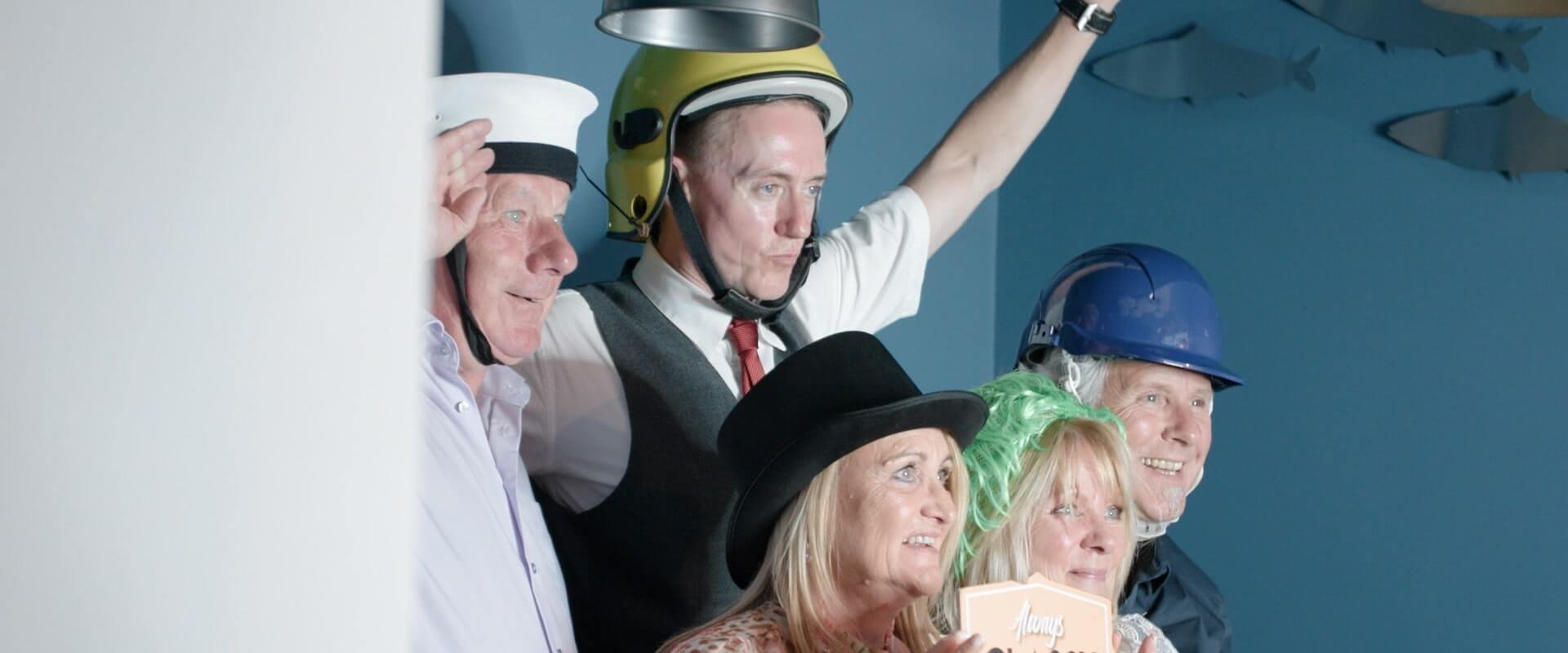 drunk wedding guests get dressed up in novelty outfits for photo booth