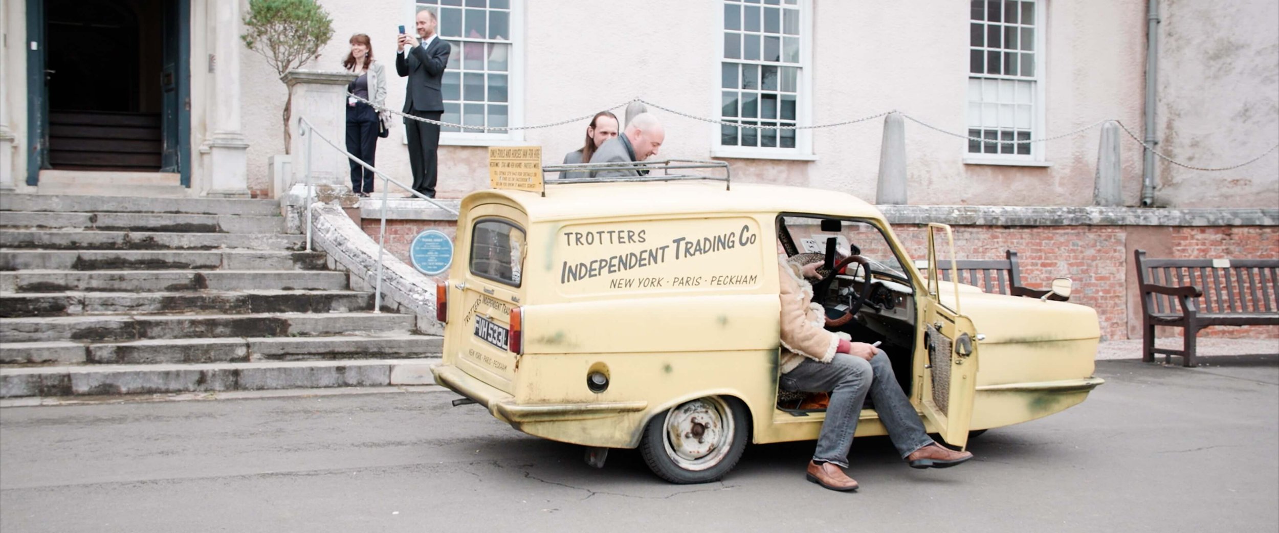 Groom exits the Only Fools and Horses themed 3-Wheeler car with a Del Boy impersonator