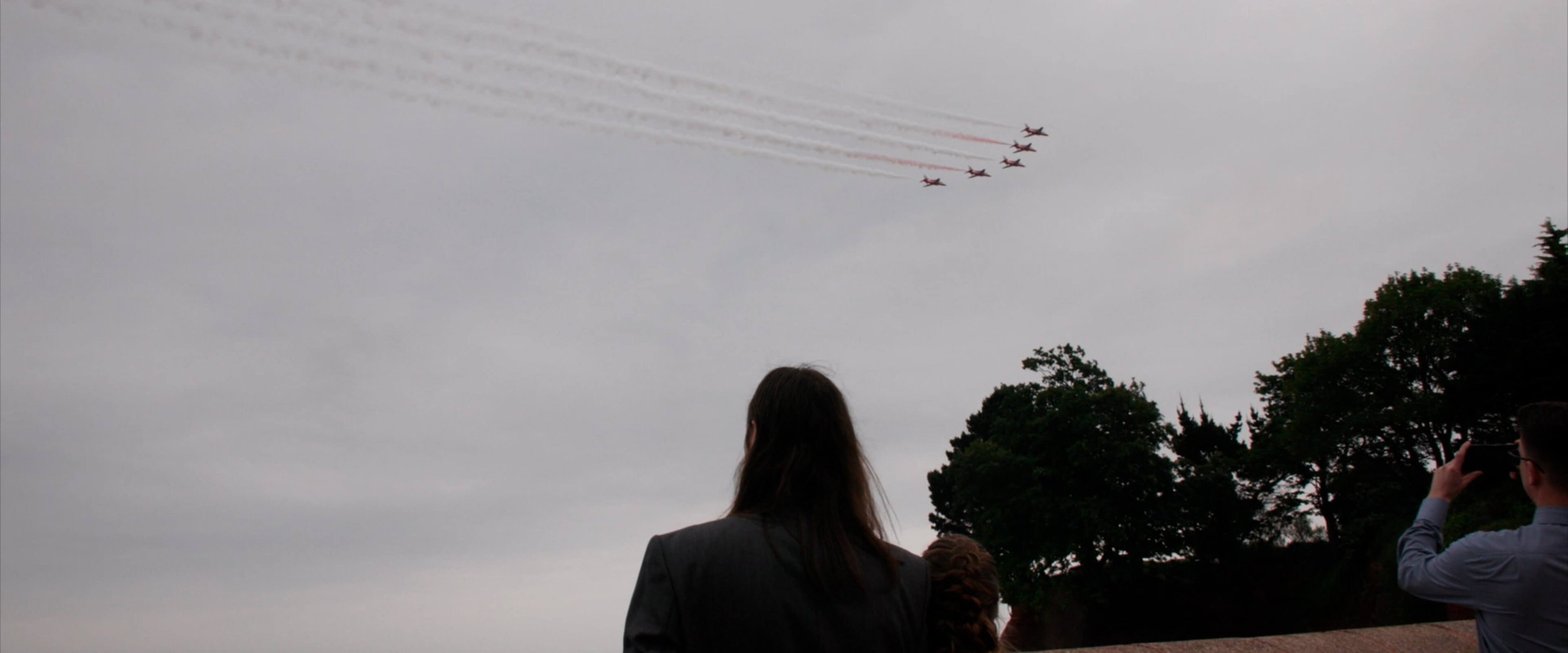 Candice and Colin watch the Red Arrows fly over Livermead Hotel during their wedding reception