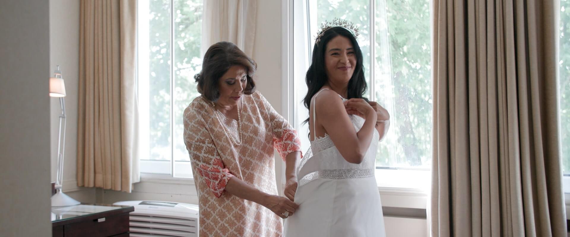 Ritas mother buttons up Rita's wedding dress on the morning of her wedding