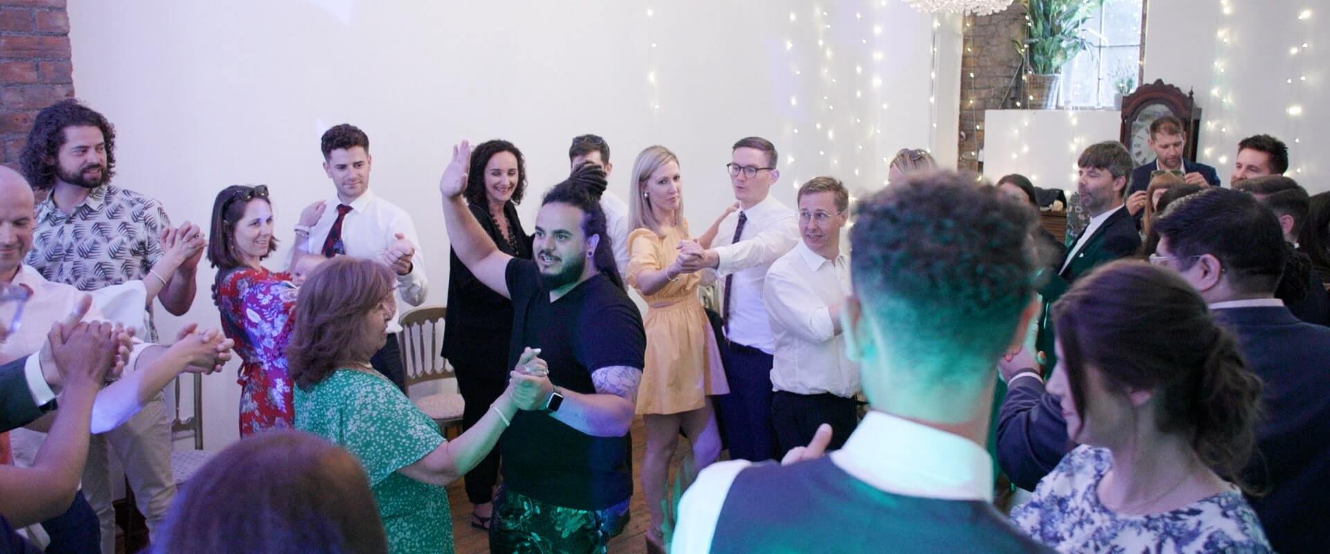 Salsa instructor teaching the wedding party how to perform the basic moves.