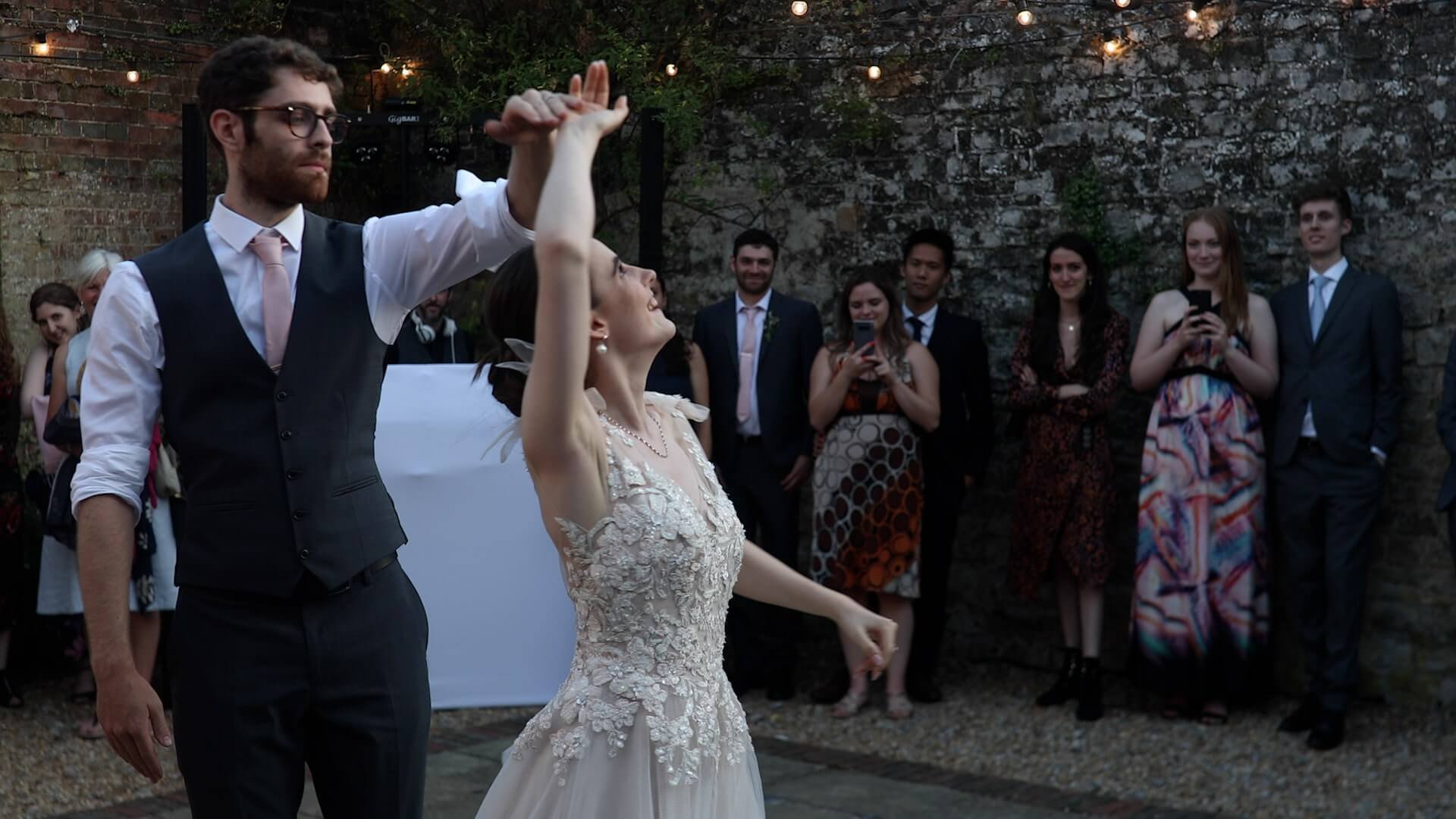 Callum twirls Toni during the first dance whilst guests joyfully watch and film on their films